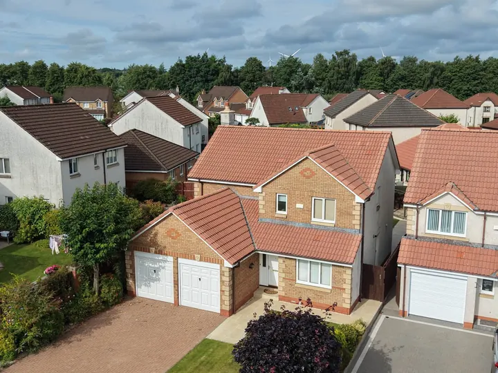 Detached house with tiled roof and double garage from the air