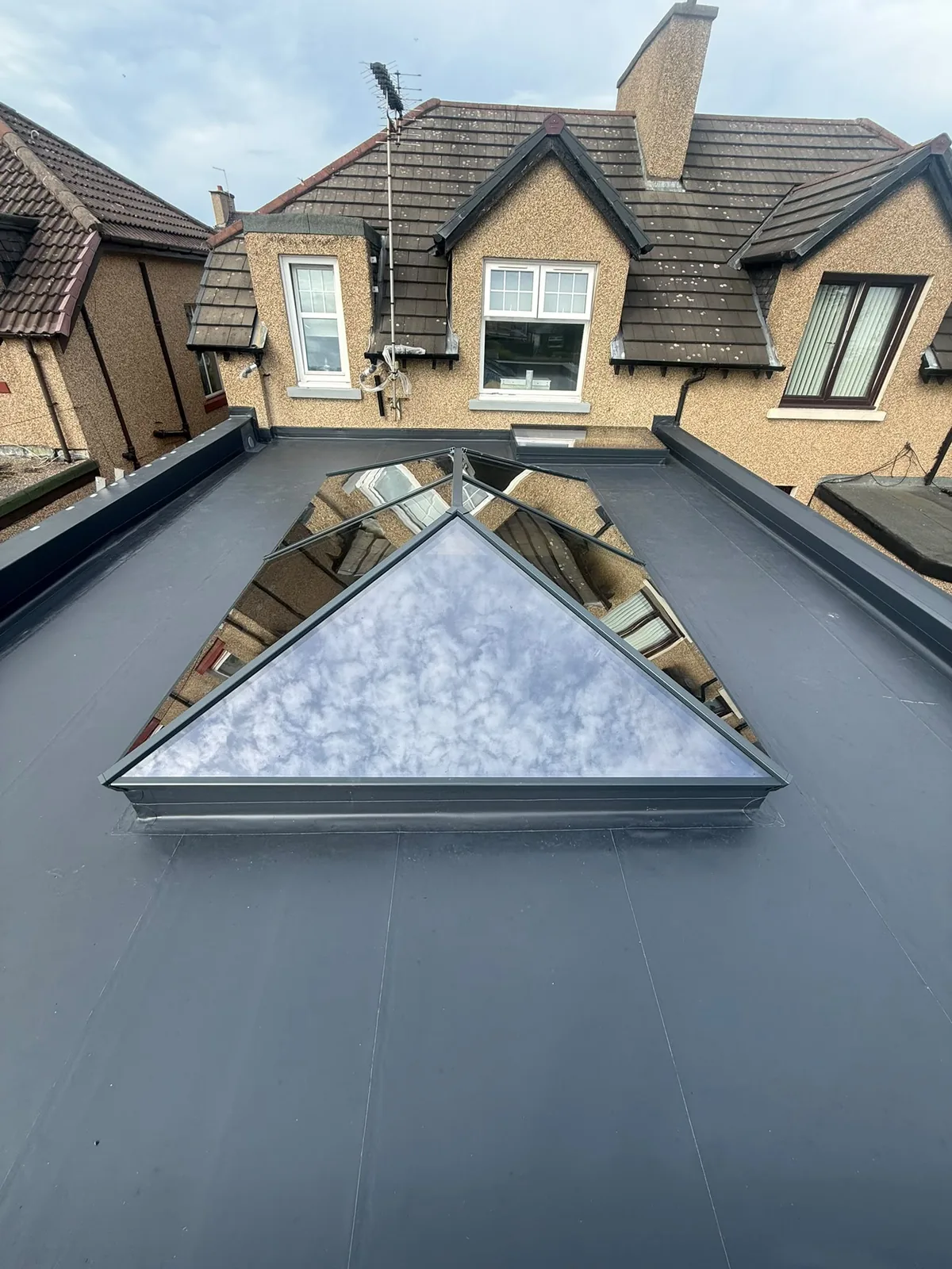 Grey GRP fibreglass flat roof with a glass lantern rooflight